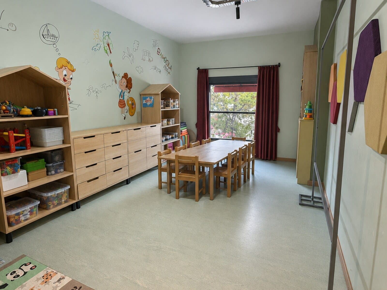 Bambola atölye sınıfı, oyuncak ve malzeme dolapları ile çocuk masaları