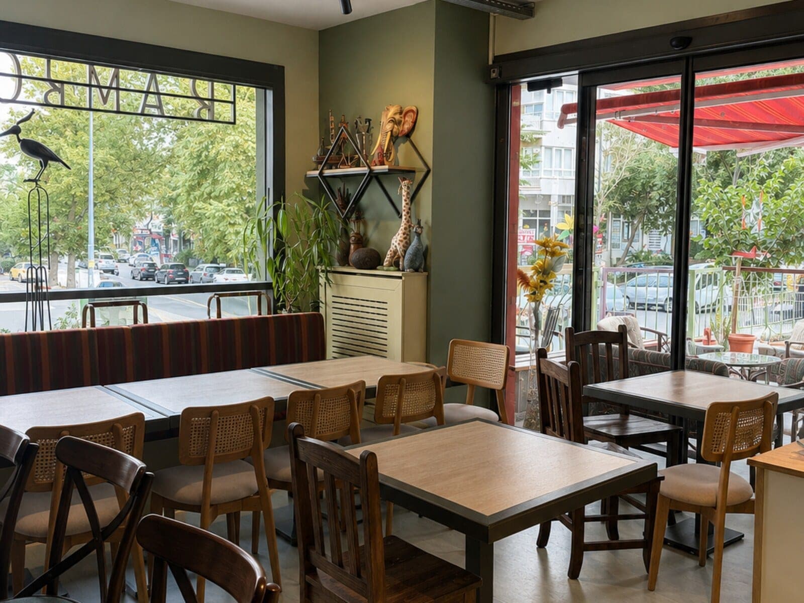 Bambola kafe iç mekânı, cadde cepheli pencereler ve ahşap oturma grupları